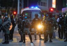 China warns US, UK against meddling in Hong Kong Police stand guard on a street after clearing a road block during a march marking the anniversary of the Hong Kong handover from Britain to China, Wednesday, July. 1, 2020, in Hong Kong. Hong Kong marked the 23rd anniversary of its handover to China in 1997, and just one day after China enacted a national security law that cracks down on protests in the territory. (AP Photo/Vincent Yu)