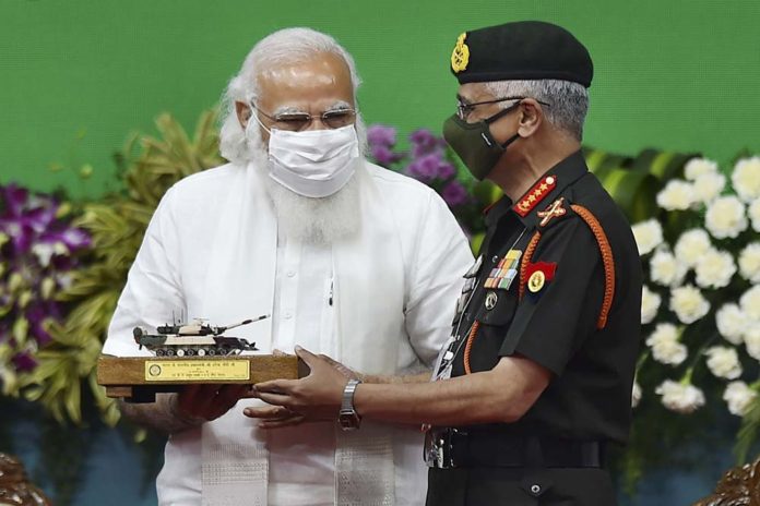 Prime minister Narendra Modi handing over a replica of the Aerjun Mk 1A tank to Gen MM Naravane, Chief of the Army Staff
