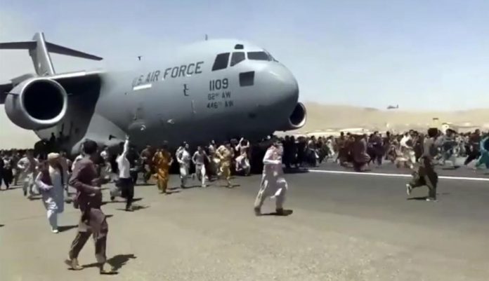 Afghans desperate to be evacuated from Kabul follow a US C-17 Transport while it takes off.