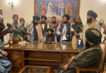 Afghanistan Under Taliban Rule Taliban fighters in the presidential palace pose at the desk of Ashraf Ghani, the departed president, 15 August 2021.
