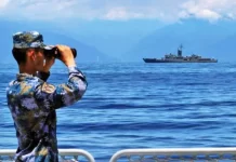 China’s Operational Structure and Activities on its Periphery 2021-22 A Peoples Liberation Army member looks through binoculars during military exercises as Taiwans frigate Lan Yang is seen in the background.