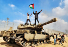 EDITORIAL – The Hamas Terrorist Attack of 7 October Members of Hamas's armed wing hold a Palestinian flag atop an Israeli tank in Gaza City on Oct. 7.